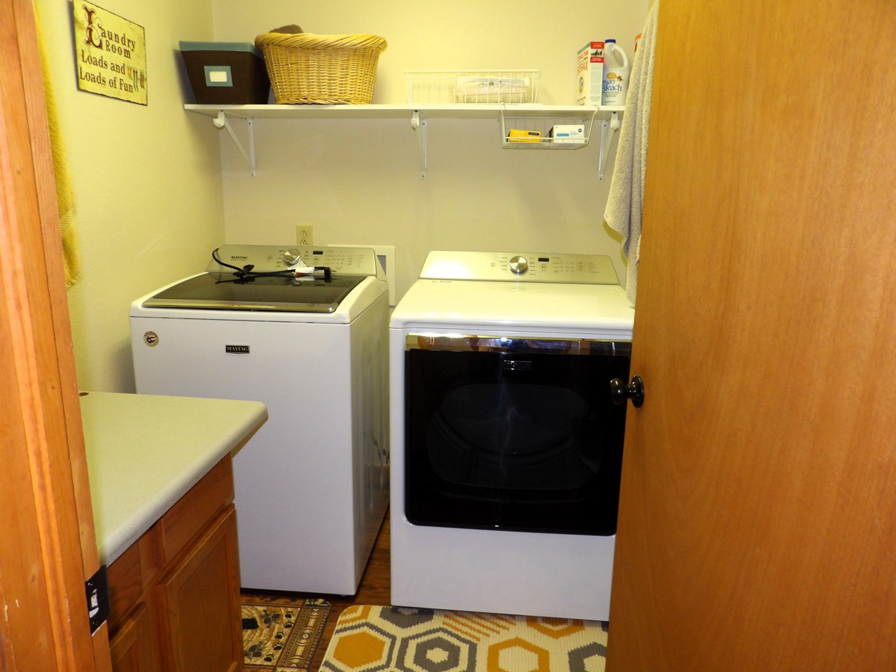 the first door down the hall on the right is the laundry room with maytag large capacity washer and dryer